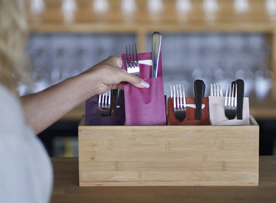 Assorted coloured convenient cutlery pockets in dispenser